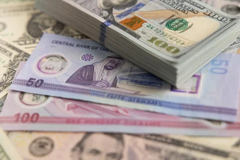US dollar banknotes stack on United Arab Emirates dirham bills close up Stock Photos