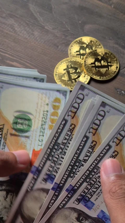 US dollar bills and bitcoin coins on a wooden table Stock Footage 327175200