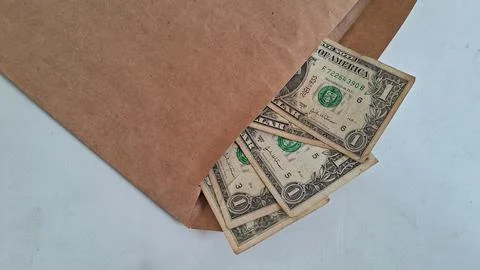US dollar bills inside a brown paper envelope. Cash savings stored in a simple Stock Photos