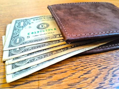 US dollar bills inside a leather wallet. Financial concept of money management Stock Photos