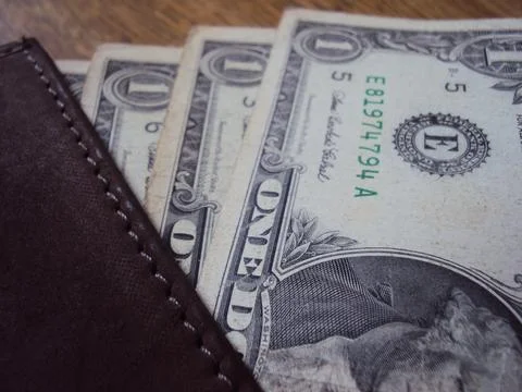 US dollar bills inside a leather wallet. Financial transaction and cash storage. Stock Photos