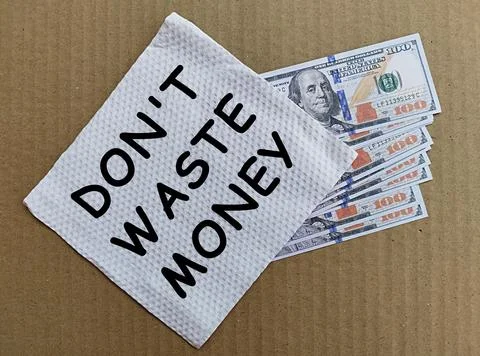 US Dollar under a layer of white tissue with the words don't waste money Stock Photos