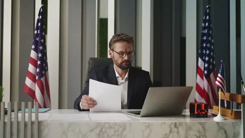 U.S. embassy employee processing immigration documents and paperwork in office Stock Footage 327784625