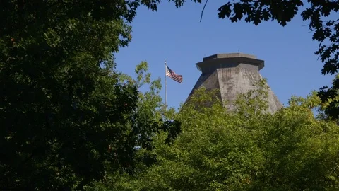US embassy in Ottawa - long view of the US flag and tower framed by foliage Stock Footage 96484379