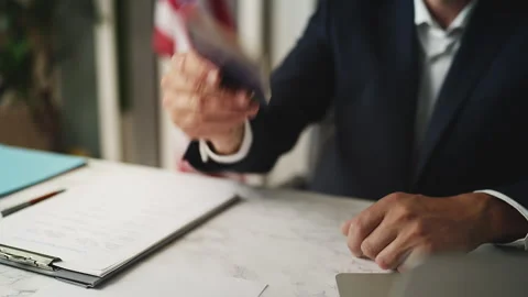 U.S. embassy worker handing passport to man during citizenship approval process Stock Footage 327784733