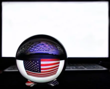 US flag and keyboard in reflection on a crystal ball against a white monitor Stock Photos