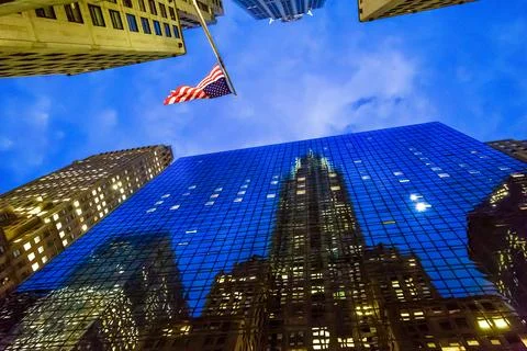US flag on the background of the sky between the houses Stock Photos