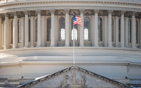 US flag on Capitol with blue background in Washington DC. Capitol with Amer.. Stock Photos