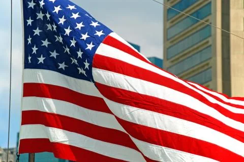 Us flag flapping in wind in baltimore inner harbor in maryland Stock Photos