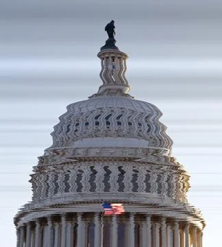 US flag flies in front of the US Capitol in Washington DC in submerged distorted Stock Photos