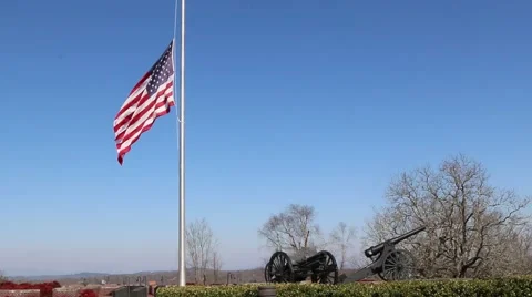 US Flag at Half Mast Waving over Hilltop Lined with Canons Stock Footage 69223769