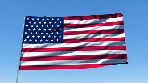 The US flag, mounted on a flagpole, flutters against a blue sky. Stockbeeldmateriaal 130002092