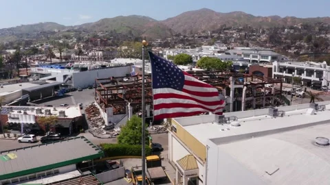 US Flag over Palisades Fire Damage in Los Angeles, California Stock Footage 309089127