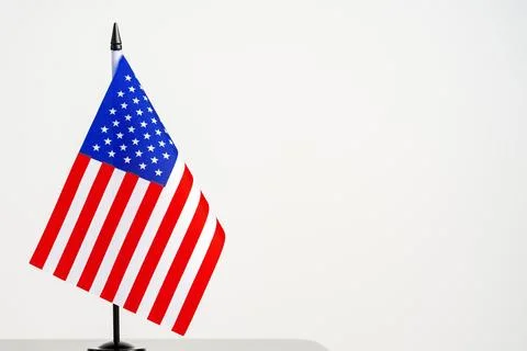 US flag stands on a table against a plain white background Stock Photos