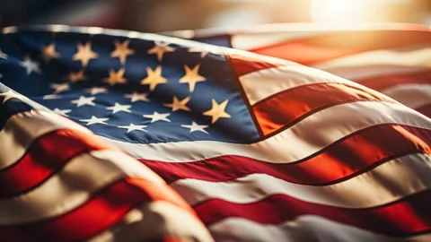 US flag undulates with sunset tones and soft bokeh Video stock 317021594