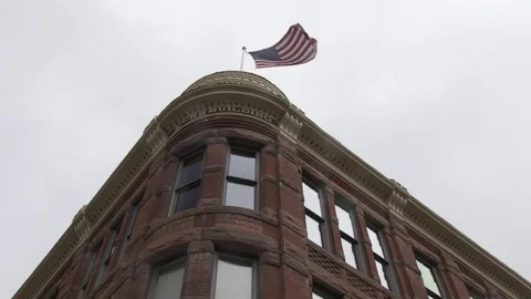 U.S. flag waving with wind on Elks building top Stock Footage 84506092