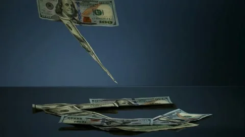 US hundred dollar bills fall onto a dark surface in slow motion Stock Footage 326628421
