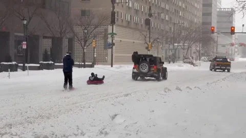 US: Jeep Pulls Sledders Through Philly Streets Amid Heavy Snowstorm Stock Footage 327683152