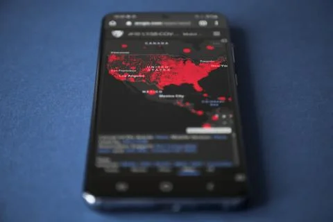 US map of coronavirus confirmed cases on the smartphone screen, blue background Stock Photos