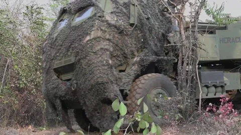 U.S. Marine HIMARS being driven with camouflage netting over cab Vídeos de archivo 235901775