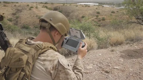 U.S. Marine operates a drone using a handheld remote control console Stock Footage 334841724