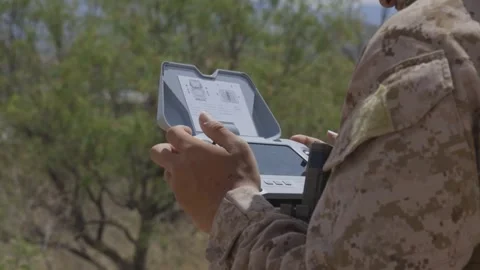 U.S. Marine operates a drone using a handheld remote control console Stock Footage 334841731