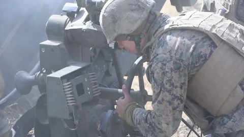U.S. Marine setting fire control on M777 Howitzer during artillery training Stock Footage 83579770
