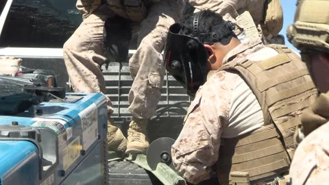 U.S. Marine uses an angle grinder to cut metal during barrier reinforcement Stock Footage 334838995