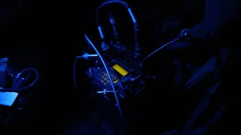 U.S. Marine using blue night vision light to operate radio transmitter Stock Footage 254557516