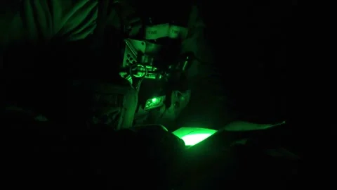 U.S. Marine using green night vision light to read paperwork Stock Footage 254557596