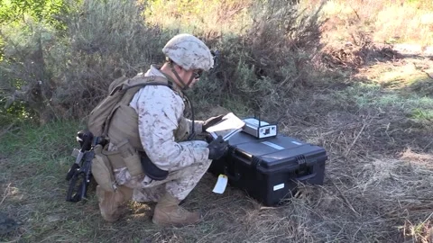 U.S. Marine using handheld tablet to operate drone Stock Footage 257891998