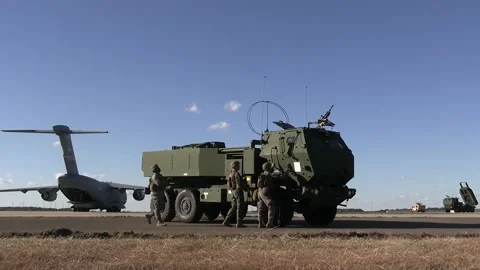 U.S. Marines approaching HIMARS vehicle near C-17 Globemaster aircraft Stock Footage 229634460