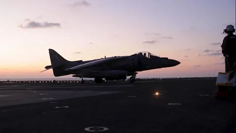 U.S. Marines AV-8B Harrier turning during sunset aboard USS Wasp (LHD 1) Stock Footage 291636991