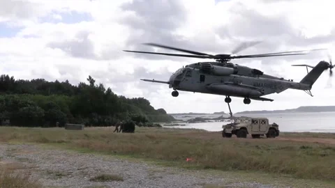 U.S. Marines CH-53 Super Stallion performing external lift on the coast Stock Footage 300344719