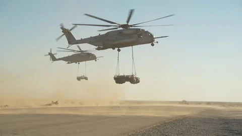 U.S. Marines CH-53E Super Stallion Helicopters perform external lift in desert Stock Footage 254402764