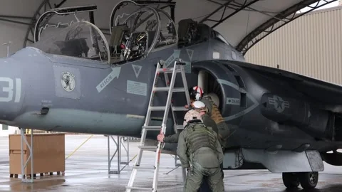 U.S. Marines co-pilot ascending stepladder to AV-8B Harrier II cockpit Stock Footage 263110699