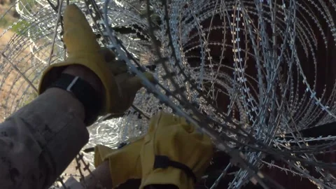 U.S. Marines conduct repair work on razor wire along the border wall Stock Footage 334839015