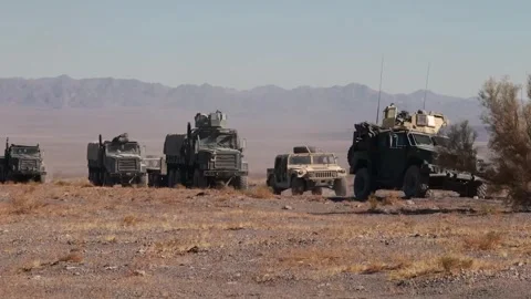 U.S. Marines driving Medium Tactical Vehicles in convoy across the desert Stock Footage 300854238