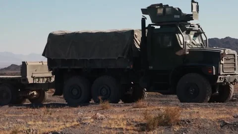 U.S. Marines driving a Medium Tactical Vehicle through the desert Stock Footage 300854239
