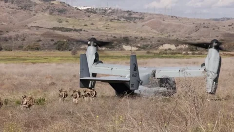 U.S. Marines exiting MV-22 Osprey in scrubland Stock Footage 256972182