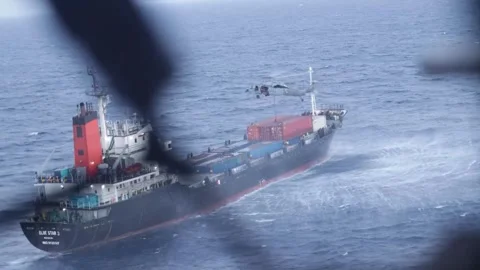U.S. Marines fast-rope from an MH-60 Seahawk helicopter onto a container ship Stock Footage 334772690