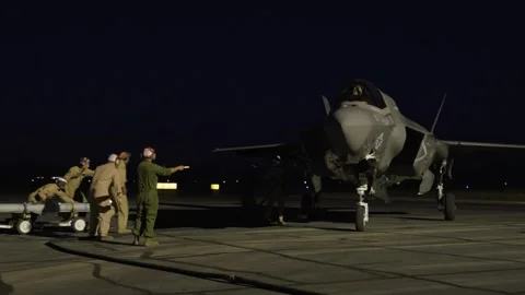 U.S. Marines hot loading munitions onto F-35B Lightning II aircraft at night  Stock Footage 273292582