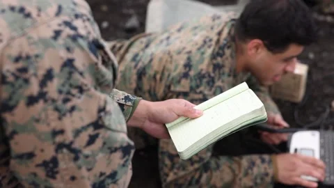 U.S. Marines inputting data from notebook into laptop computer Stock Footage 232394180