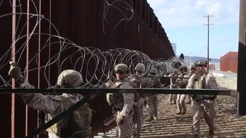 U.S. Marines installing razor wire on Mexican border wall for additonal security Stock Footage 300344914