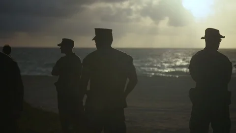 U.S. marines interacting with each other on the beach Stock Footage 117734663