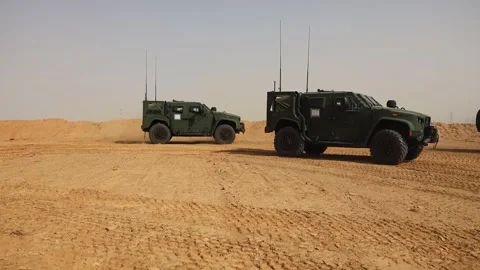 U.S. Marines Joint Light Tactical Vehicles driving in Saudi Arabian desert Stock Footage 276089378