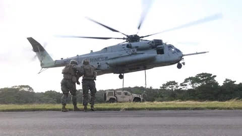 U.S. Marines move away as CH-53 Super Stallion performs lift of Oshkosh JLTV Stock Footage 255284136