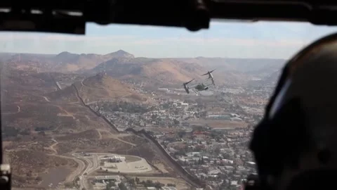 U.S. Marines MV-22 Osprey flying over the U.S.-Mexico border wall in California Stock Footage 300854518
