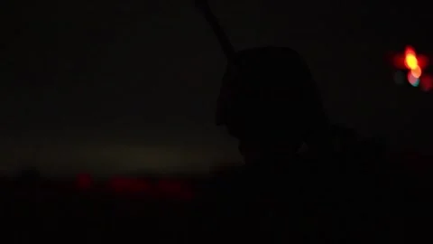 U.S. Marines observing a target being hit at night by an aircraft firing weapons Stock Footage 295620402