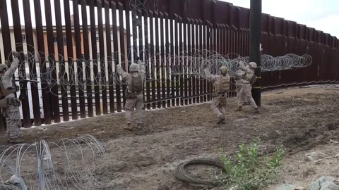 U.S. Marines placing razor wire on Mexican border wall for additional security Stock Footage 300344953
